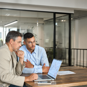 Two accountants viewing IBISWorld data on a laptop